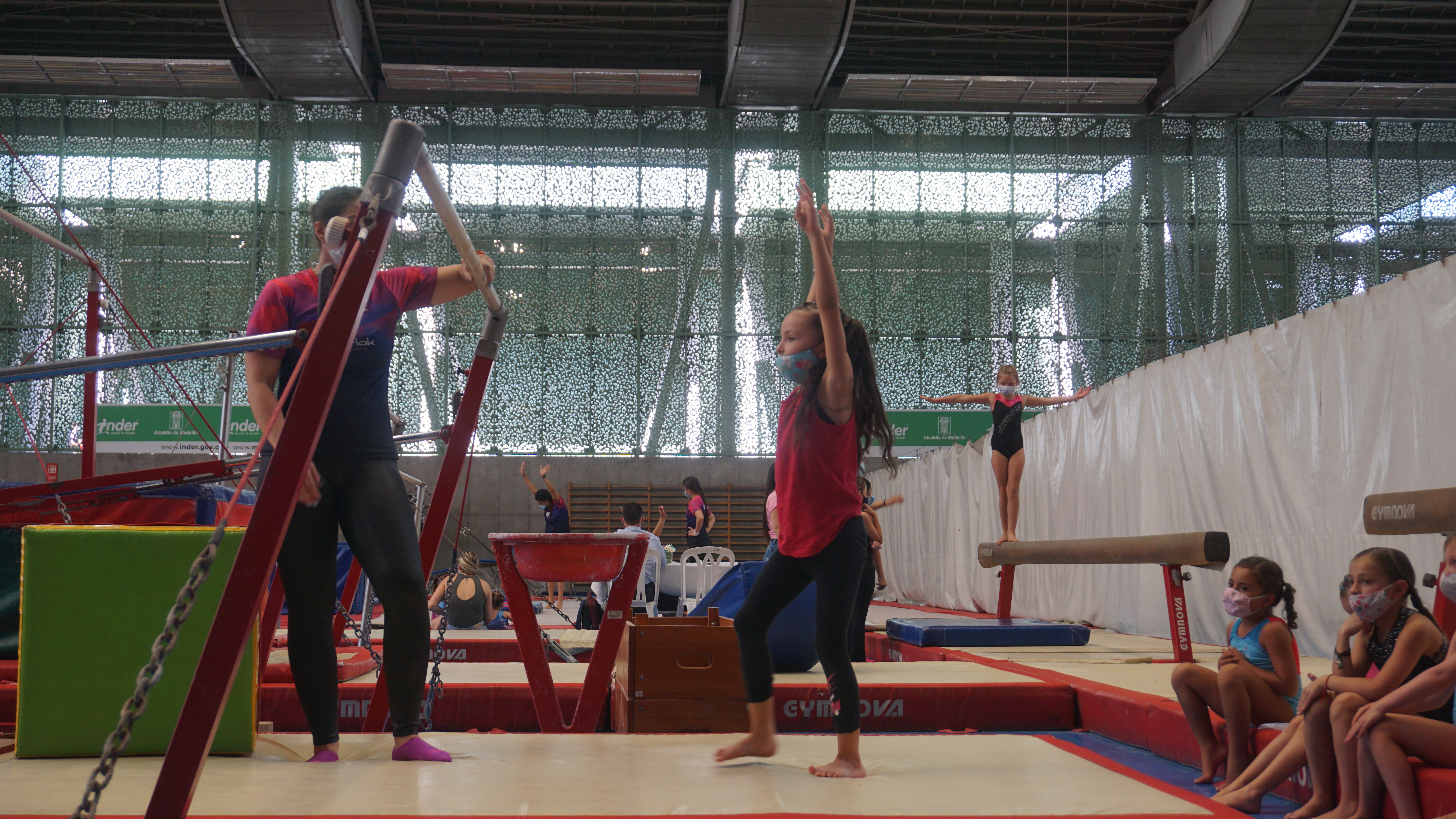 Entrenador asistiendo a una gimnasta en clase personalizada
